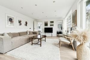 un soggiorno con un divano e un tavolo di Bright Summer House With Pool In Tisvildeleje a Tisvildeleje