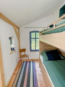 una camera da letto con un letto a castello e una sedia di Charmning Cottage At The Edge Of The Uckermark a Grambow