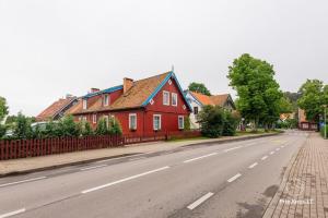 a red house on the side of a street at Ramus poilsis in Nida
