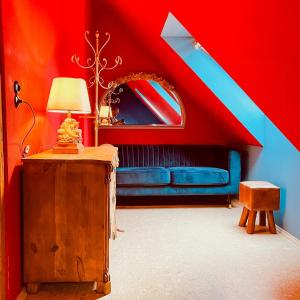 a room with a blue couch and a red ceiling at Cozy Holiday Apartment In The Manor House in Rambin
