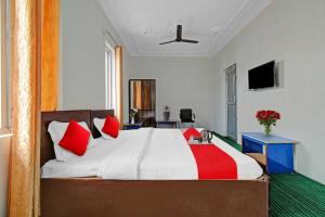 a bedroom with a large bed with red pillows at Collection O Rajbagh Post Office in Srinagar