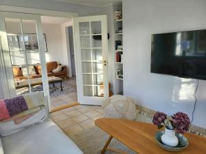 a living room with a tv on a wall at Country House With Large Garden On Langeland in Humble