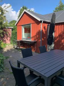 a picnic table and chairs in front of a red building at Cozy Red Cottage By Kalø Vig With Seaview in Hornslet