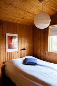 Un dormitorio con una cama grande en una pared de madera. en Authentic Family Summer House At The Limfjord, en Roslev