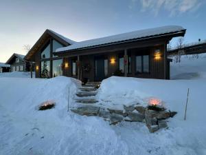 a house with a pile of snow in front of it at Family Cabin At The Foot Of Gaustatoppen in Rjukan
