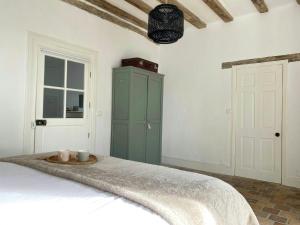 a bedroom with a bed with a green cabinet at Peaceful Cottage Near Saint-Savin Abbey in Journet