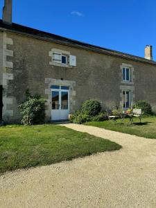 a building with a blue door and a bench at Peaceful Cottage Near Saint-Savin Abbey in Journet +7 photos