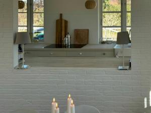 two candles sitting on a table in front of a mirror at Beach House In Liseleje in Liseleje