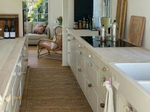 a kitchen with a sink and a counter with wine bottles at Beach House In Liseleje in Liseleje