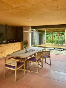 een houten tafel en stoelen in een kamer met een keuken bij Japanese-Inspired Nature Gem In Vejby Strand in Vejby