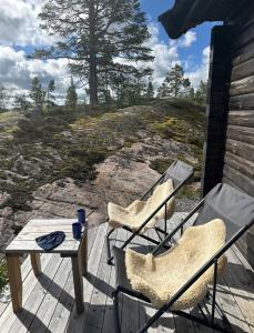 two chairs and a table on a deck with a view at Family Cabin With Norefjell Mountain Views in Lampeland
