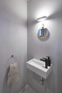 Un baño blanco con lavabo y espejo. en Idyllic Vineyard Retreat Near Klingenmünster, en Klingenmünster