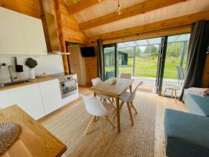 盖瑟Charming Holiday Home Near The Beach的配有桌椅的厨房和客厅
