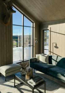 a living room with a couch and a large window at Modern Cabin By Skeikampen's Ski Trails in Svingvoll