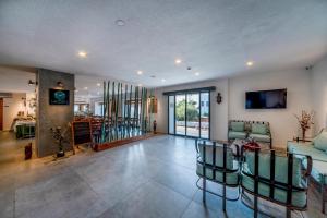 Una sala de estar con sillas, un sofá y un televisor. en laden hotel bodrum, en Bodrum City