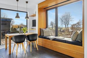 Un comedor con una mesa y un gran ventanal. en Light Flooded Holiday House On The Baltic Sea, en Ahrenshoop