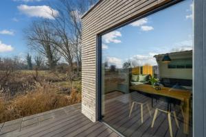Una puerta corrediza de vidrio en una terraza con un escritorio. en Light Flooded Holiday House On The Baltic Sea, en Ahrenshoop
