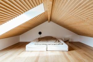 a bed in a room with a wooden ceiling at Newly Built Summer House With Sea View in Haderslev