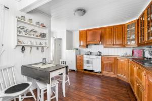 a kitchen with wooden cabinets and a table and chairs at Explore Håøya Nature Reserve in Helgeroa