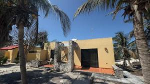 a house with two palm trees in front of it at Matraca 74 in Celestún +4 photos