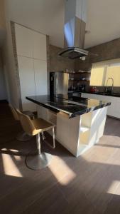 a kitchen with a black counter and a chair at Matraca 74 in Celestún