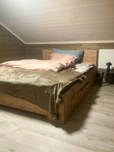 1 cama con marco de madera en una habitación en Mountain Cabin With Panoramic Views In Savalen, en Tynset