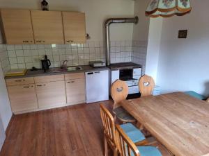 a kitchen with a wooden table and a table and chairs at Tauernbergalm in Heiligenblut +14 photos