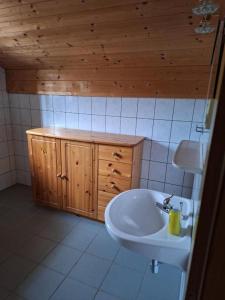 a bathroom with a white sink and a wooden ceiling at Tauernbergalm in Heiligenblut