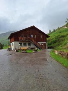 a barn sitting on top of a green hill at Tauernbergalm in Heiligenblut