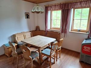 a dining room with a wooden table and chairs at Tauernbergalm in Heiligenblut