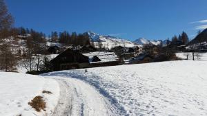 pokryta śniegiem droga z wioską w tle w obiekcie Monolocale Milky Way - Sestriere w mieście Sestriere +5 zdjęć
