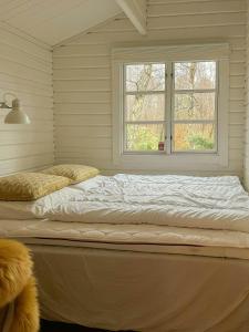 a large bed in a room with a window at Summerhouse In Forest Near Rørvig Beach in Nykøbing Sjælland