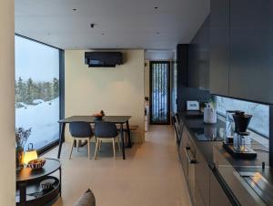 a kitchen with a table and a dining room at Modern Cabin By Snøhetta At Blefjell in Svene