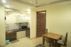 a kitchen with a wooden table and a wooden door at Mount Valley Mama Cottage in Rishīkesh