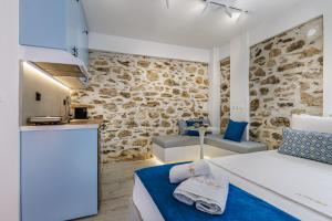 a kitchen and a bedroom with a bed and a counter at Le Petit Bati Blue in Skopelos Town