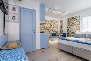 a bedroom with two beds and a kitchen in a room at Le Petit Bati Blue in Skopelos Town