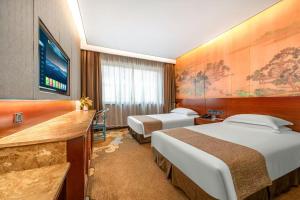 Ένα ή περισσότερα κρεβάτια σε δωμάτιο στο Eagle City Xindi Hotel