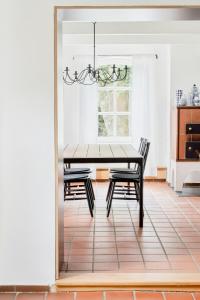 a dining room table with two chairs and a chandelier at Tradition Meets Modern In Gulf House in Ostermarsch