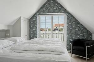 スケーエンにあるNew Holiday Home Near The Beach In Old Skagenの大きなベッドと窓のある寝室