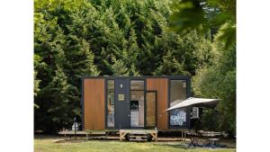 Lance FieldFassifern Tiny House 2 by Tiny Away的一个小房子,配有野餐桌和雨伞