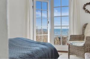a bedroom with a bed and a view of the ocean at Beachfront Summerhouse With Amazing View And Peace in Hesselager