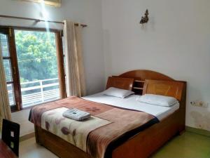 a bedroom with a bed with a large window at Mount Valley Mama Cottage in Rishīkesh