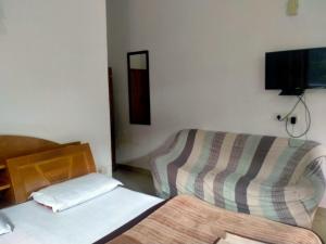 a bedroom with two beds and a tv on the wall at Mount Valley Mama Cottage in Rishīkesh