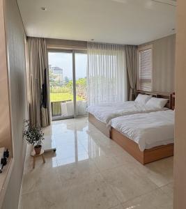 a bedroom with a large bed and a large window at Ocean View Private Pool Villa in Jeju +64 photos