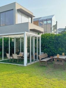 a house with glass doors and a table and benches at Ocean View Private Pool Villa in Jeju