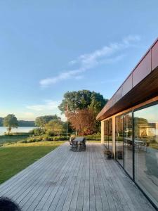 a wooden deck with benches and a building at Stylish 70'S Villa With Forest And Lake View In Ry in Ry