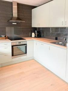 een keuken met witte kasten en een spoelbak bij Hytte Ved Heimsila I Hemsedal in Hemsedal