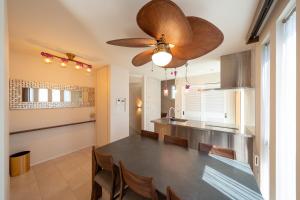a kitchen with a dining table and a ceiling fan at Villa NiuHale in Fujisawa