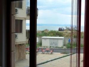 a window view of a patio with chairs and a building at Flat Lora Pomorie in Pomorie