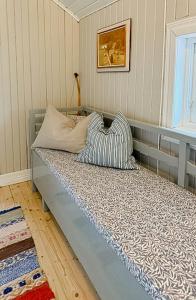 ein Bett mit zwei Kissen darauf in einem Zimmer in der Unterkunft Historic Cottage Near Wiredaholm in Aneby + 3 Fotos